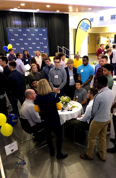 A group of student athletes gather around Kathy Selck '98, Hall of Honor member.