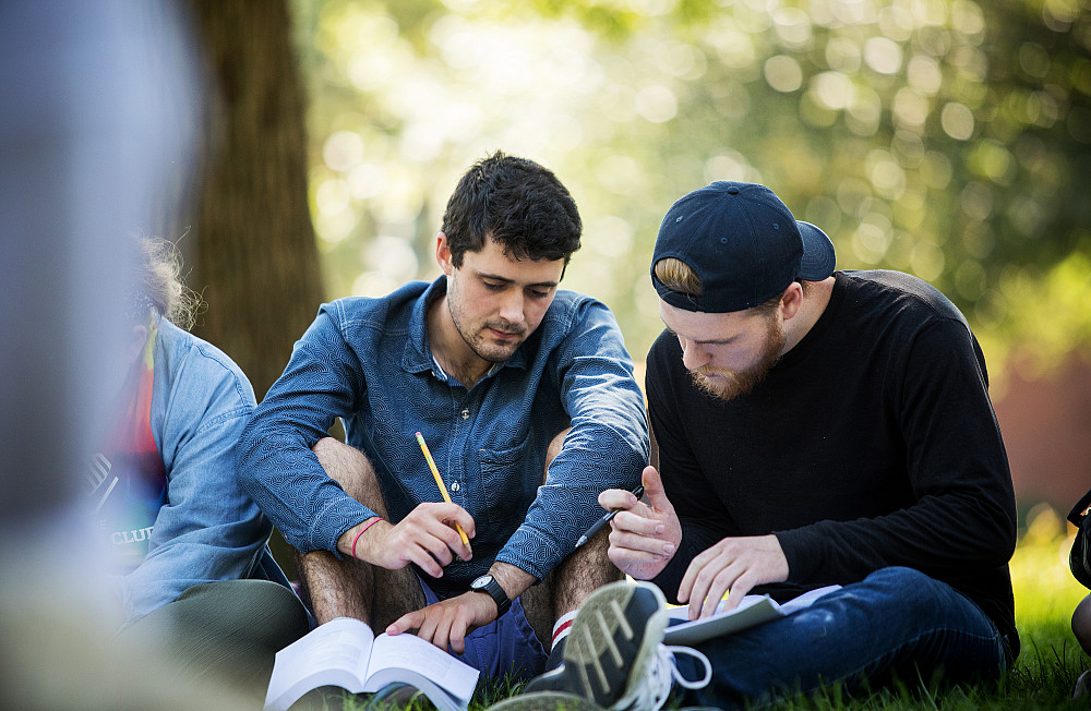 Two Beloit College students work together outdoors during class.