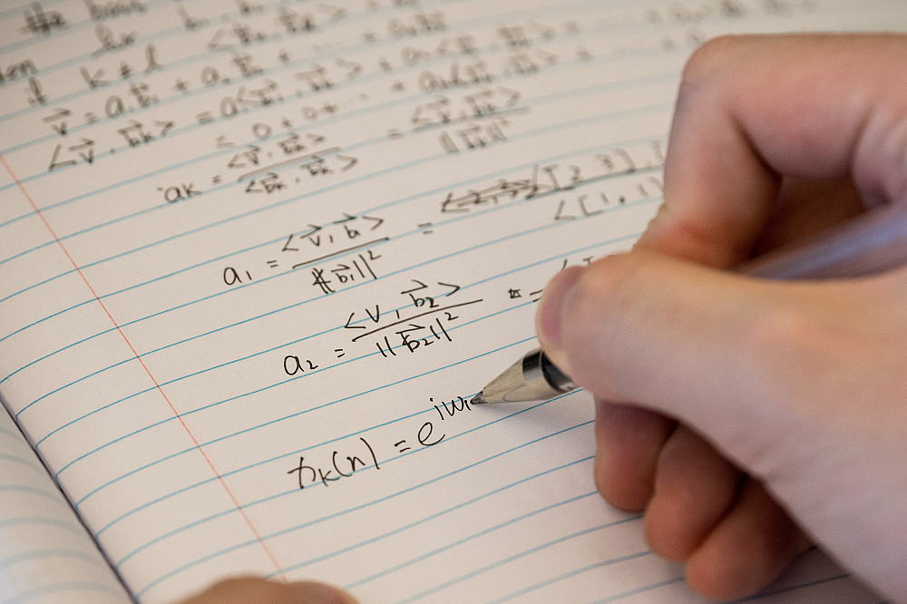 A student writing a series of Linear Algebra functions and equations.