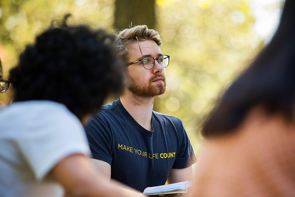 Students argue academic points with each other in a course taking place outdoors on the Beloit College campus.