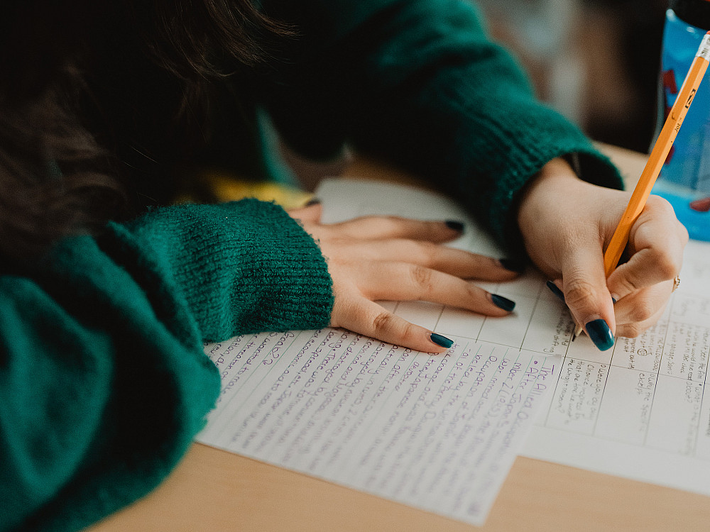 A Beloit College student writing in class.