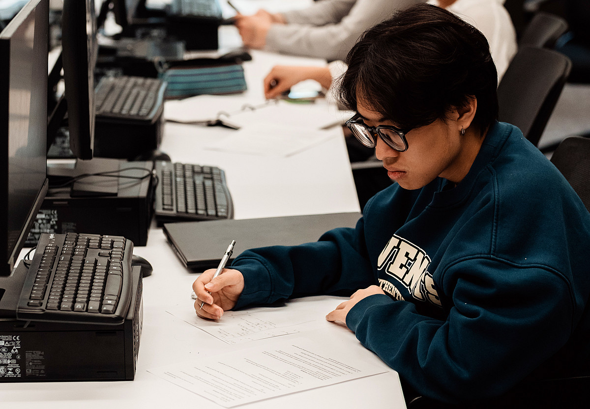 A Beloit College student in an economics computer lab takes notes during class.