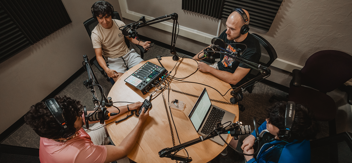 A group of students recording a podcast inside of a podcast studio.