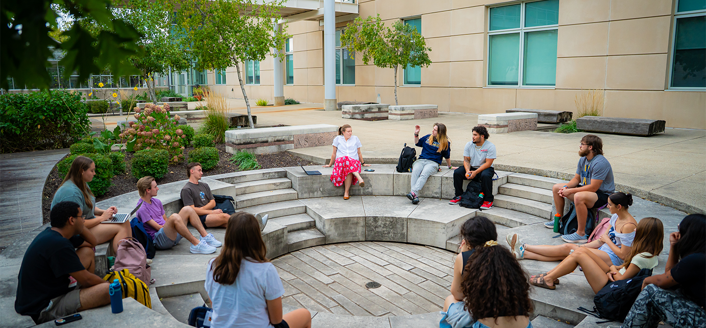A class of students sitting outside during class.
