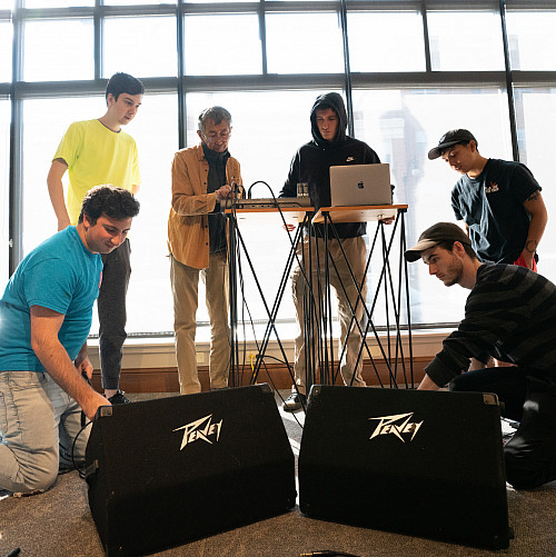 Students work with a professor on how to best arrange sound equipment.