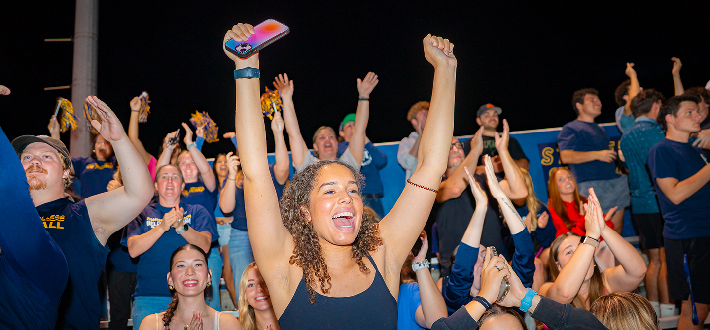A crowd of students cheer on the football team at Strong Stadium.