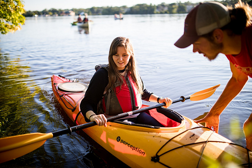 A member of the Buccaneer Boathouse group assists other students in experiencing paddle sports on...