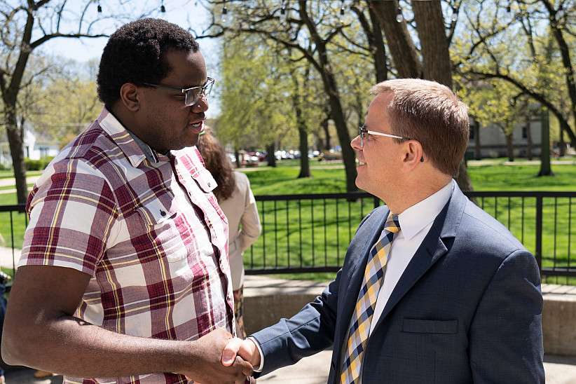 President Eric Boynton shakes hands with a fellow colleague.