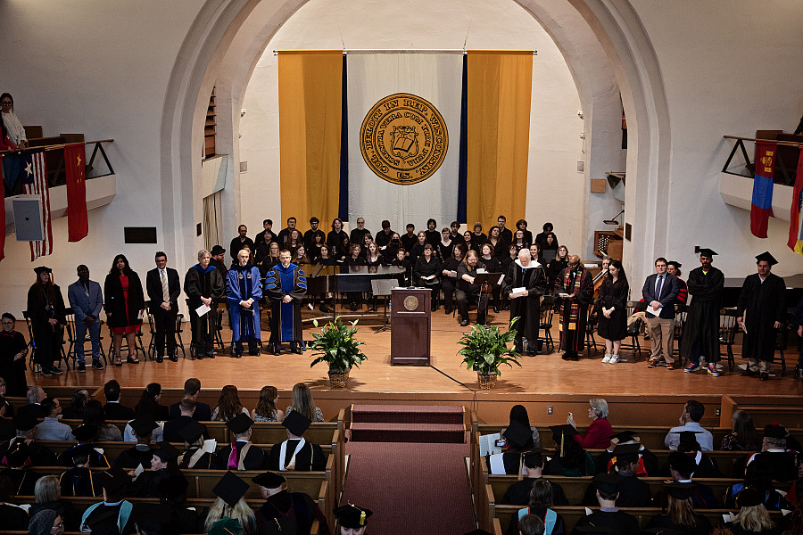 The platform party stands while faculty and staff enter Eaton Chapel.