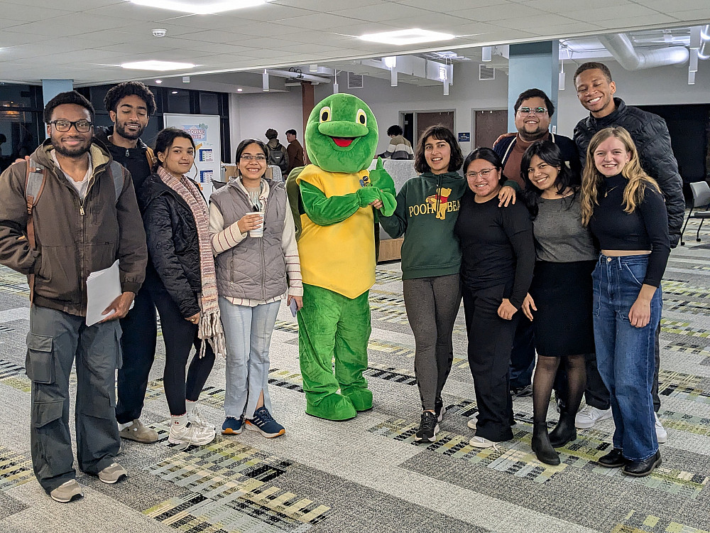 A photo of a group of students smiling and standing with Torti the LITS turtle mascot.