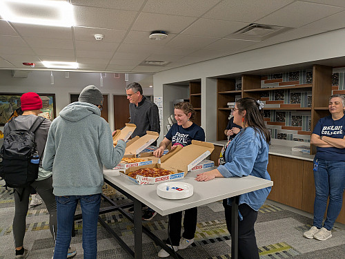 A photo of LITS staff serving pizza to students.