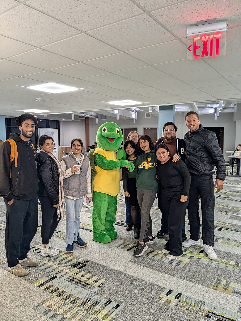 Photo of nine students standing with Torti the LITS turtle mascot.