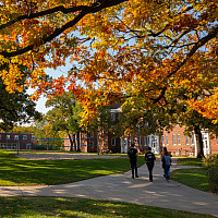 Students walk together to class under the colorful leaves of Beloit's campus in autumn.