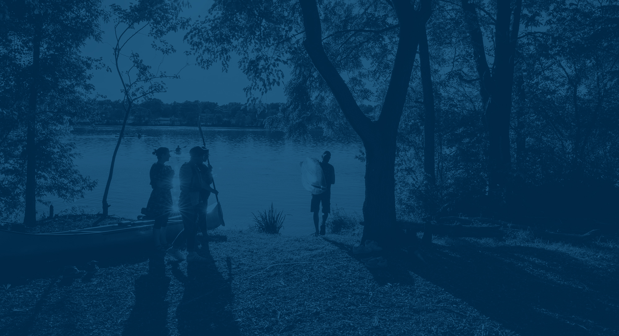 Students gather on the edge of the Rock River, preparing to go on the water.