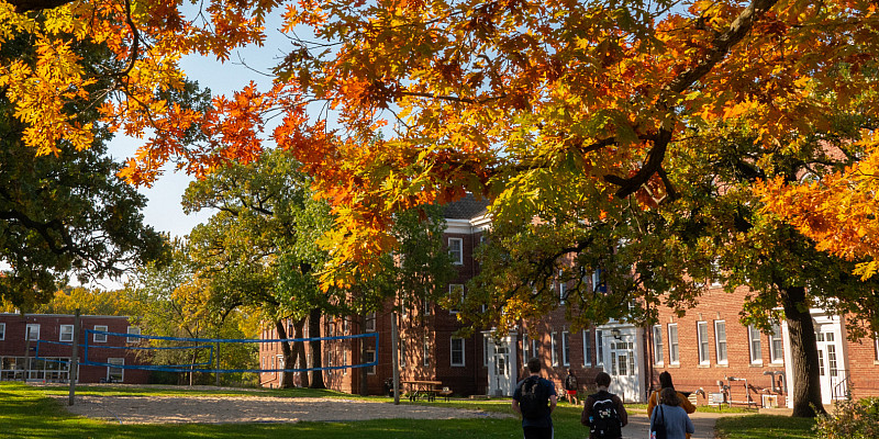 Students walk together to class under the colorful leaves of Beloit’s campus in autumn.