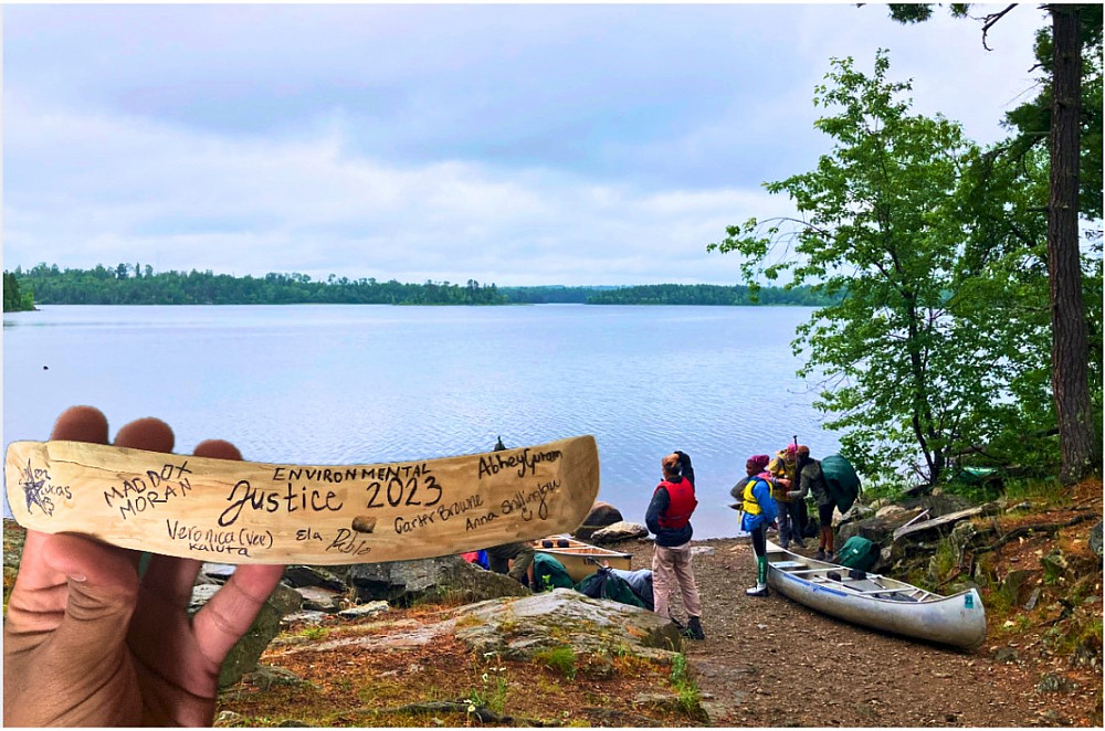 Abhey resting at a portage with a signed memento from the trip.