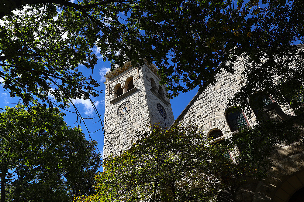 A view of the steeple of Eaton Chapel through trees and foliage.