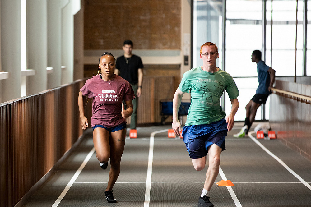 Two students run down the track at the Powerhouse in an race.