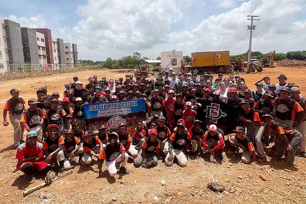 A group of college students and kids pose for a picture.