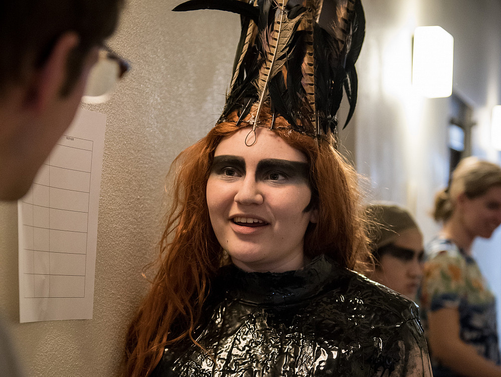 A theatre professor instructs a student backstage before their performance.