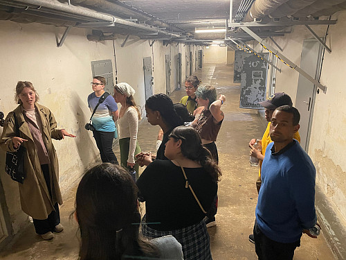Students listening to a tour guide in a cell block at the Stasi Museum in Berlin.