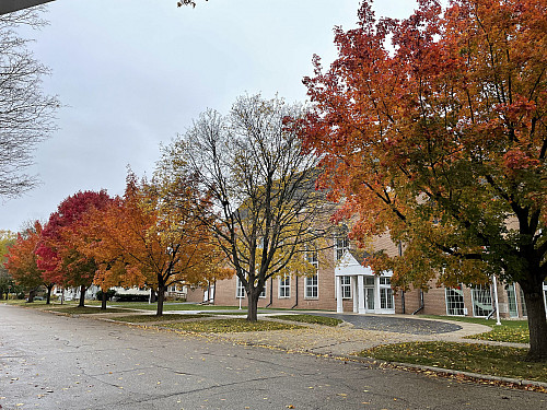The side entrance of First Congregational Church, with Bushnell St and brightly colored fall leaves in front of it.