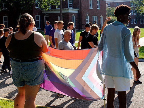 Clubs, organizations, faculty, staff, and students line College Street as the new class of students parade between.