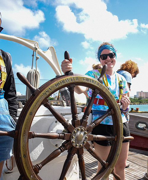 Kaylie steering her SEA Semester ship, the SSV Corwith Cramer.