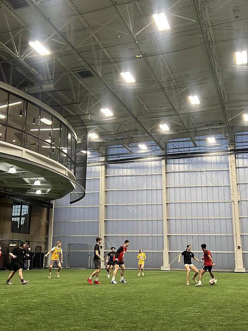 Student dribbling a soccer ball during a intramural soccer game.