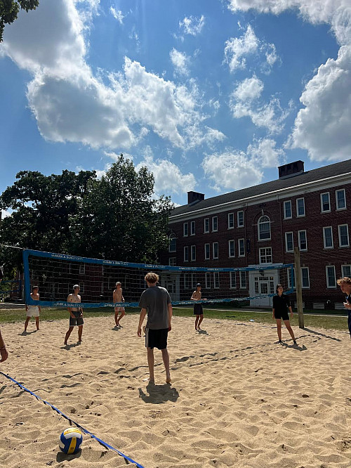 Students waiting for a serve in an intramural sand volleyball game.