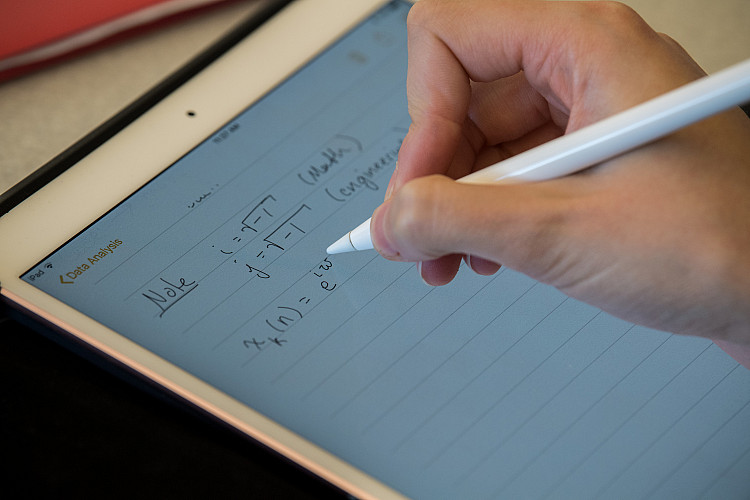 Student taking notes in a data analysis class.