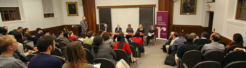 A group of panelists address a crowd in Richardson Auditorium on the wealth and well-being of nations during the Miller Upton Forum.