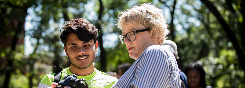 Professor of Art Meredith Root explains camera settings to a student.