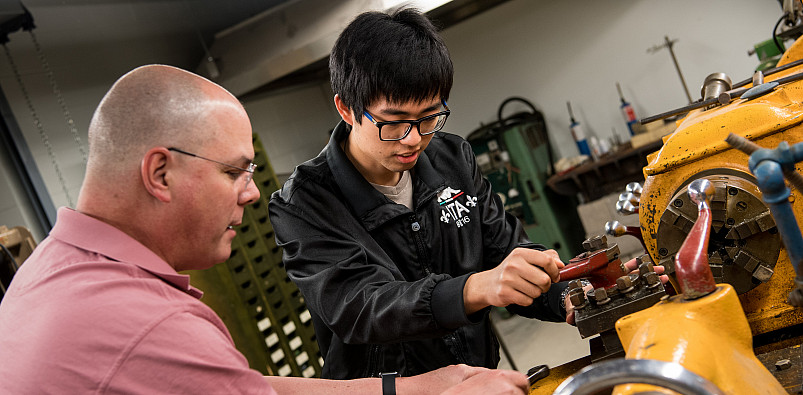 Students work one-on-one with a physics professor in the workshop lab.