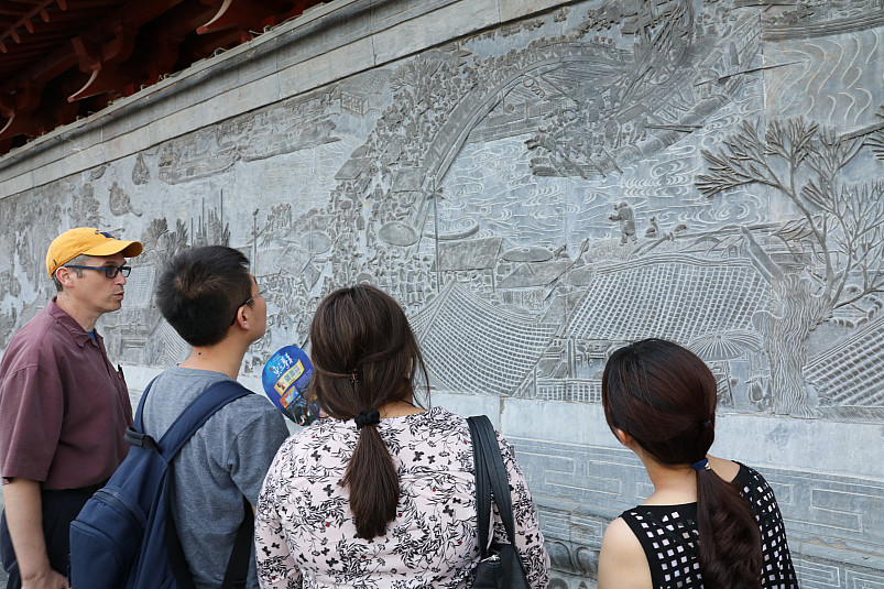 Professors and students study a relief panel in the Yellow river area of China during the Landsca...