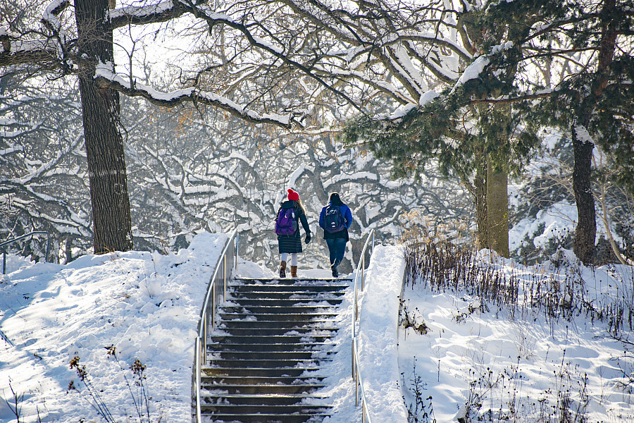 Two students ascend a snow covered stairway on the Beloit College campus.