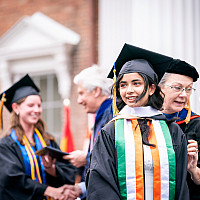 A student looks towards the crowd as they receive their diploma during Commencement.