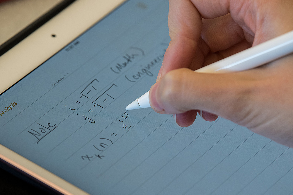 A student makes notes for a data analytics course, noting the different notations used by mathematics and engineering.