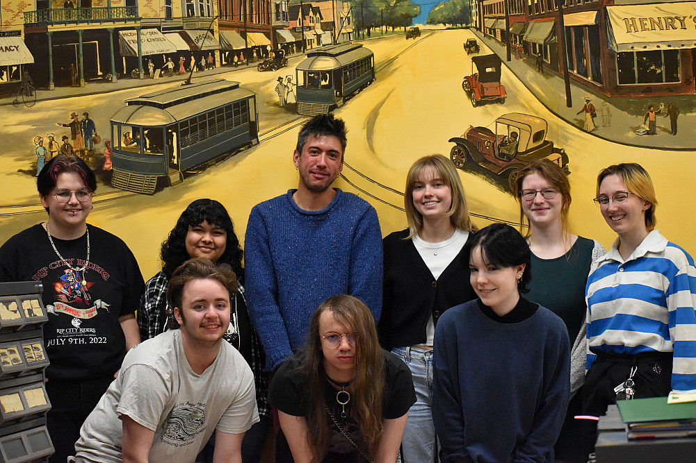 Prof. Michael Dango with Students at the Beloit Historical Society in front of a mural in the library