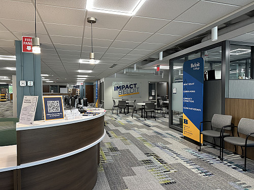 Reception desk to the left, chairs and office space to the right and table chairs in the background