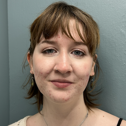 A professional portrait of a student, in front of a gray wall.