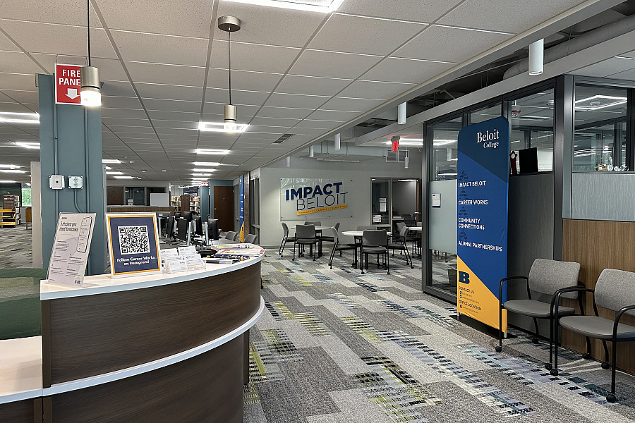 Reception desk to the left, chairs and office space to the right and table chairs in the background