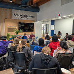 Students gather in the School of Business hub to listen to James McQuaid ’11.