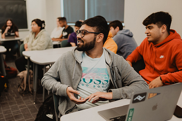 A student speaks to the room in the middle of an economics class.