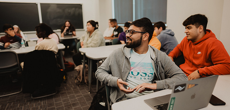 A student speaks to the room in the middle of an economics class.