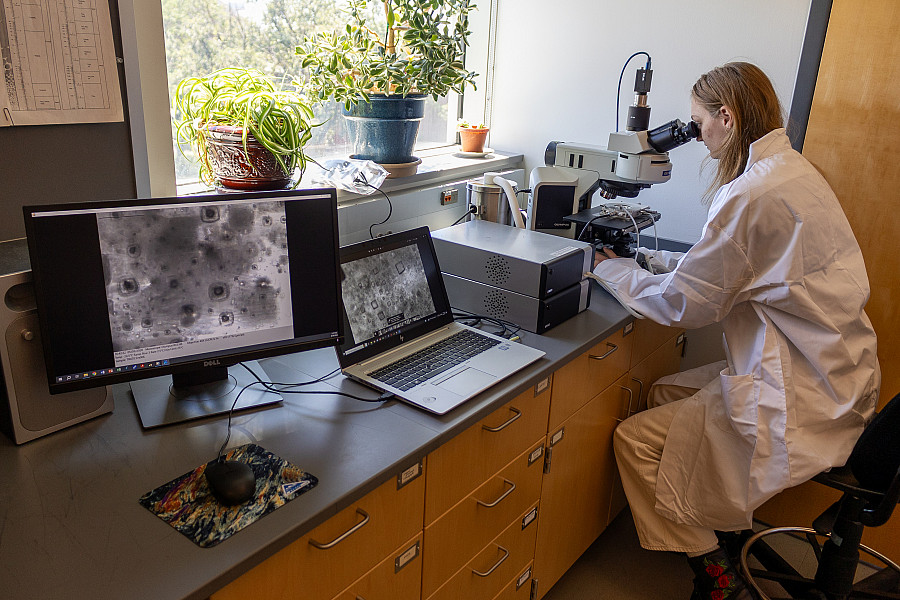A student using an advanced optical microscope.