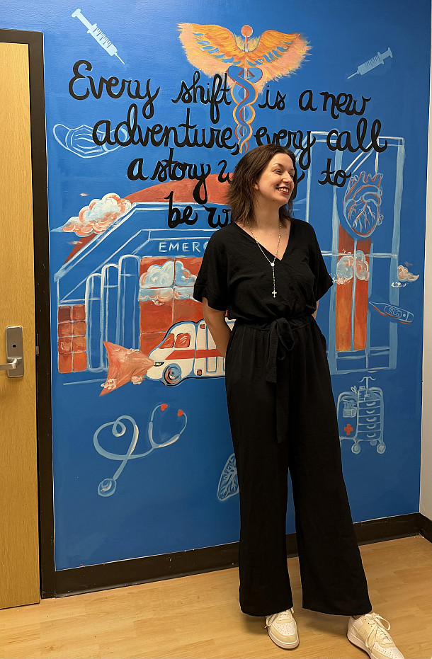 Hannah Flynn '28 poses in front of her completed mural.