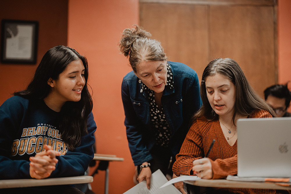 Professor Sylvia Lopez helps two students in their Spanish coursework.