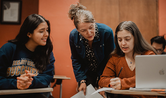 Professor Sylvia Lopez helps two students in their Spanish coursework.