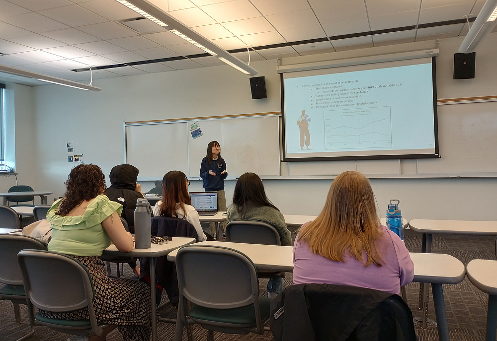 a student delivers a symposium presentation